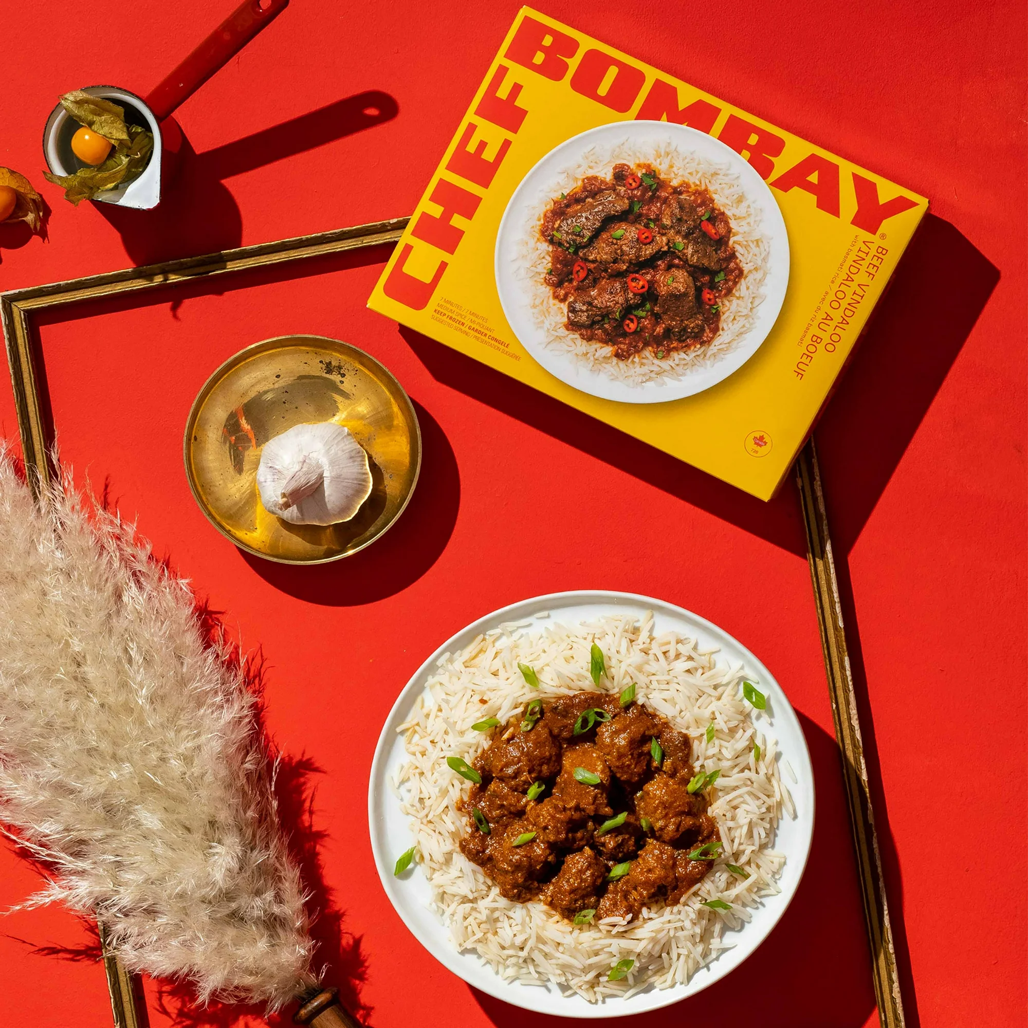 Chef Bombay Beef Vindaloo in a bowl against a red background.