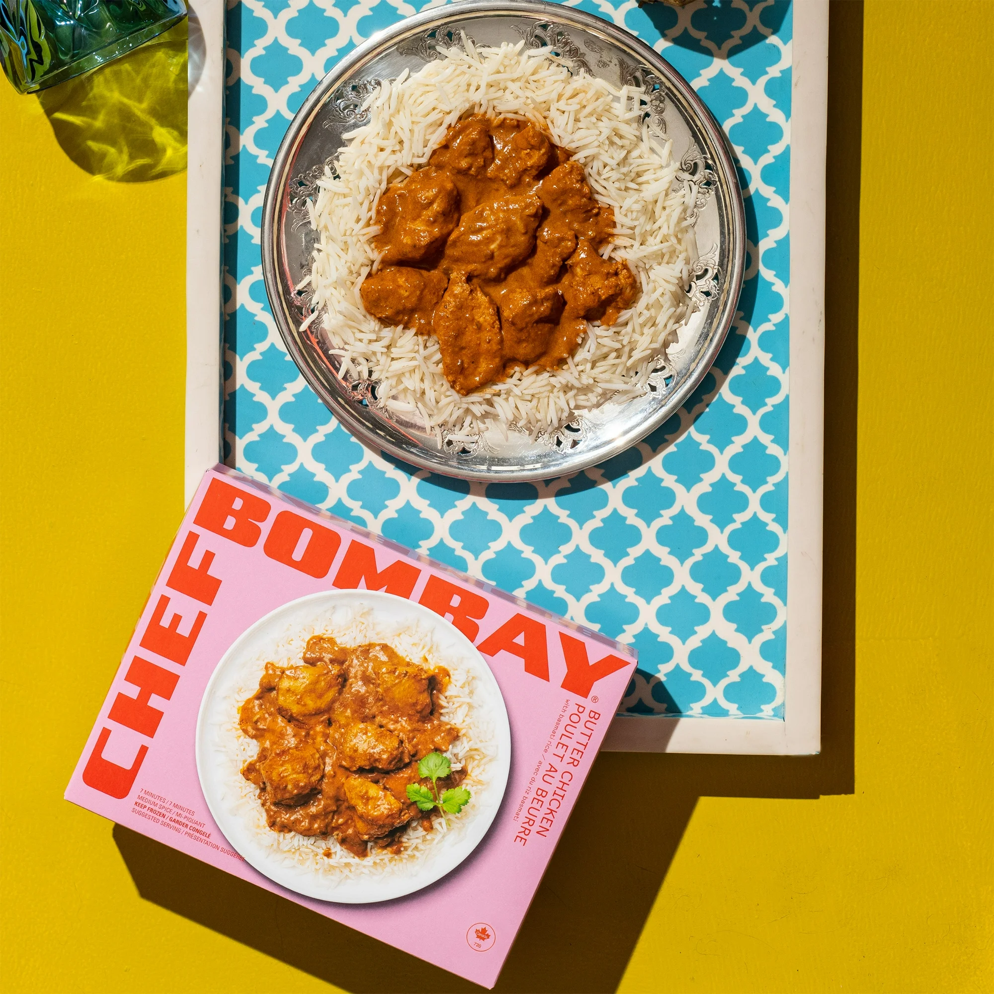 Chef Bombay Butter Chicken in a bowl against a yellow background.