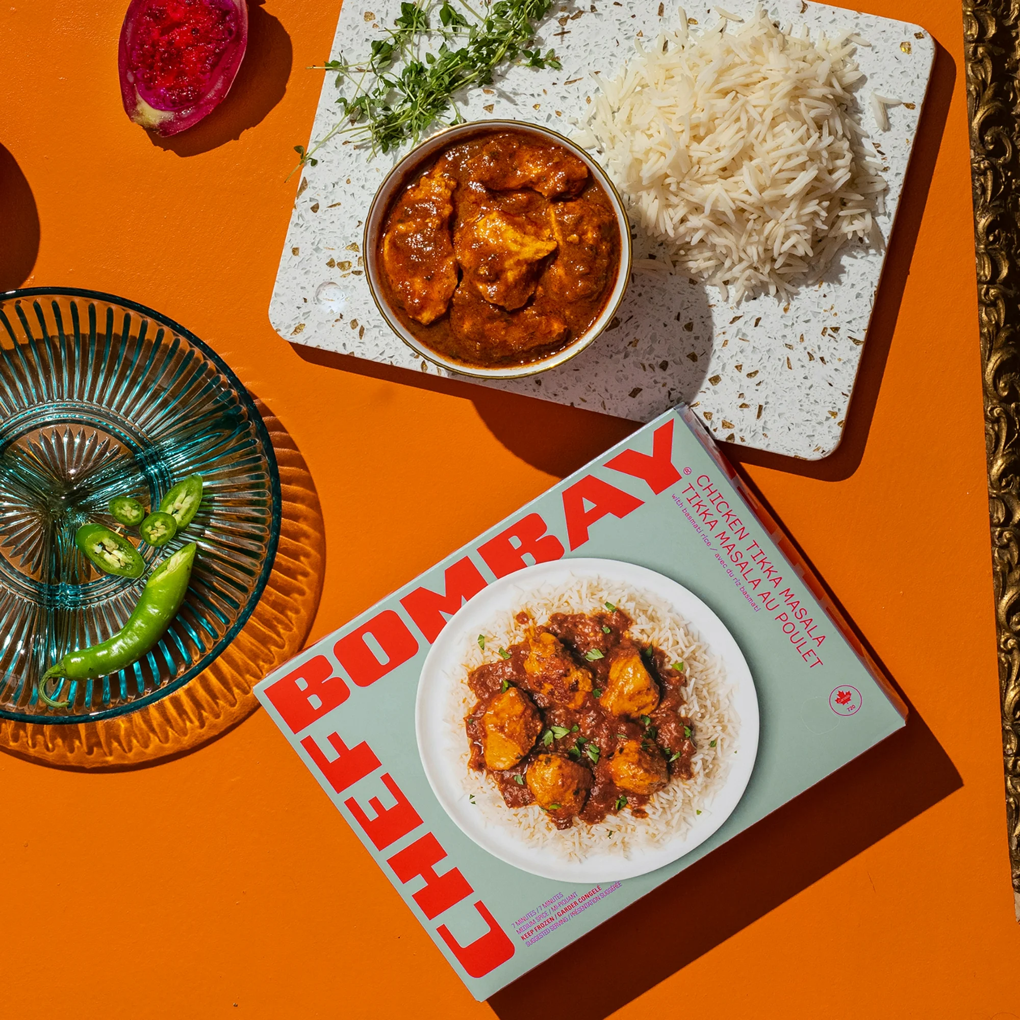 Chef Bombay Chicken Tikka Masala in a bowl against an orange background.